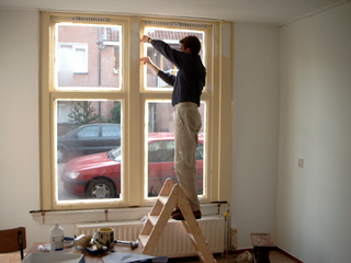Alex geeft de kozijnen een likkie verf